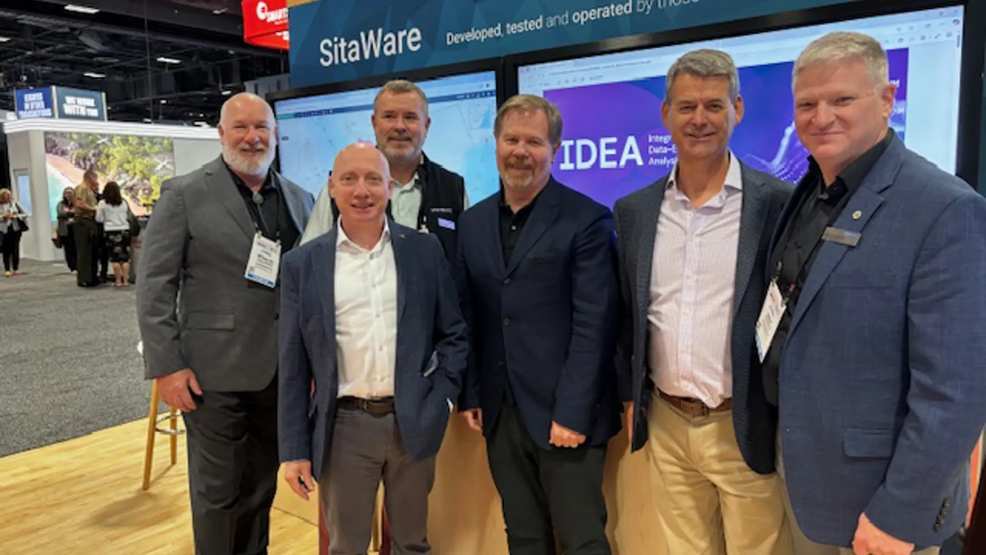 ScenarioAI staff and Systematic Staff pose at the Systematic booth during the Modern Day Marine tradeshow