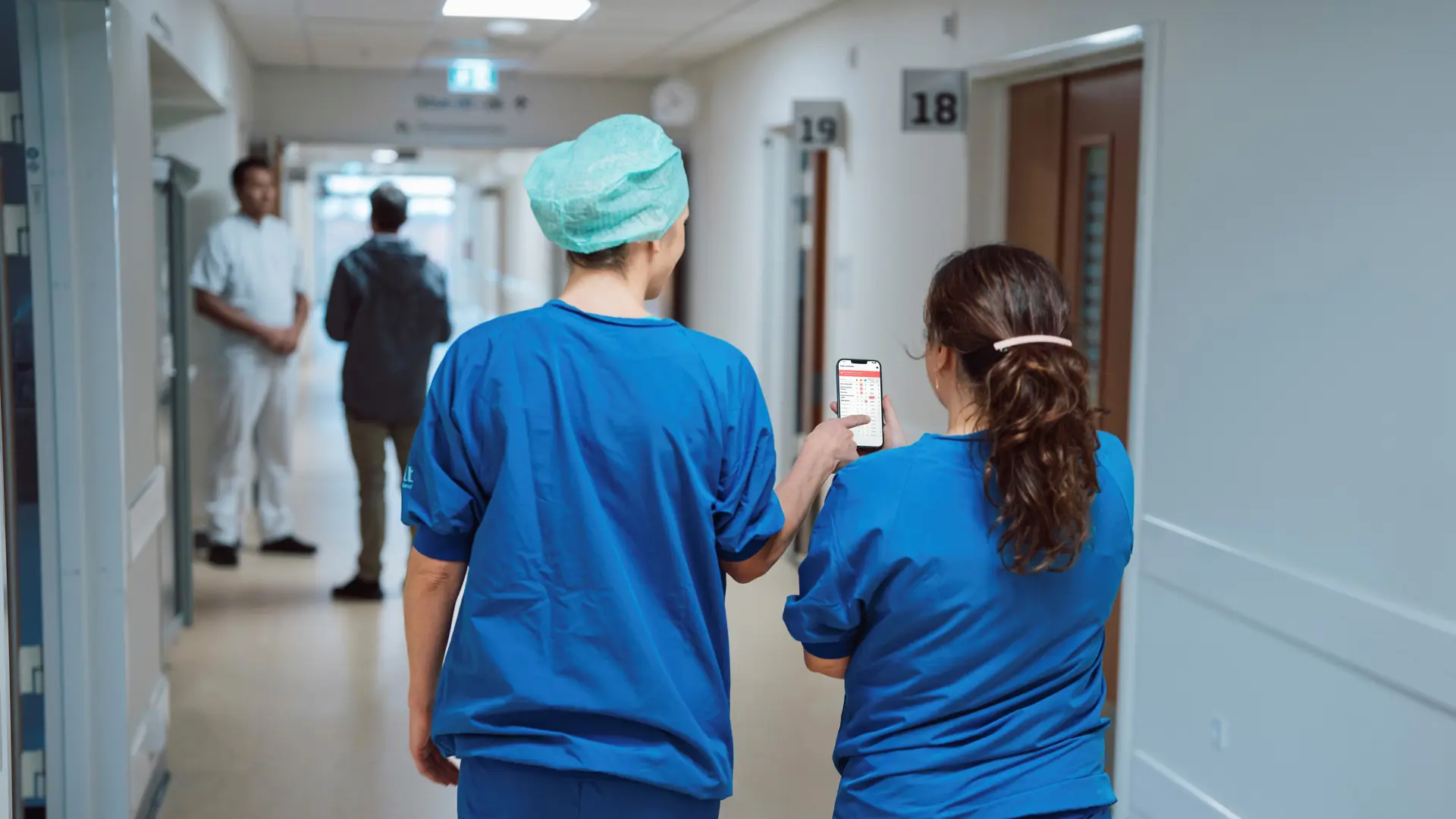 Nurses viewing a phone displaying the Columna Flow Command Centre interface in a hospital hallway.
